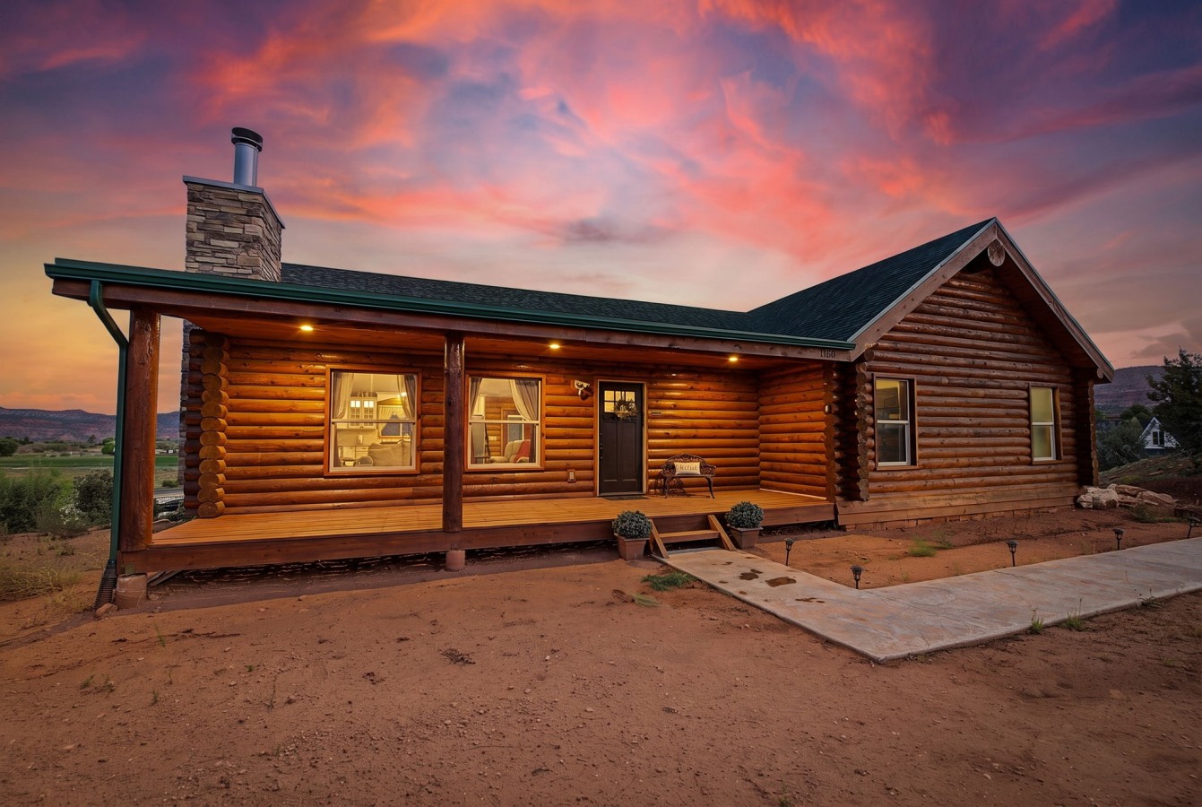 Cliffrose Cabin's log exterior and front porch at sunset, Kanab, UT